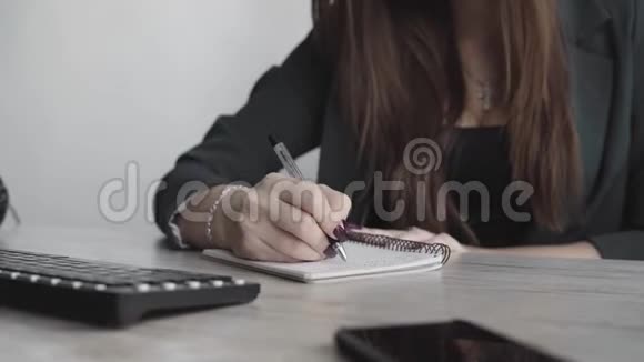 女商人在笔记本上写东西创业女企业家学生在工作场所学习书写笔记视频的预览图