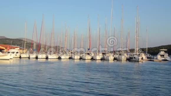 游艇和豪华游艇在码头停泊在码头的船只游客在海上的港口乘船停靠在岛上的游艇视频的预览图