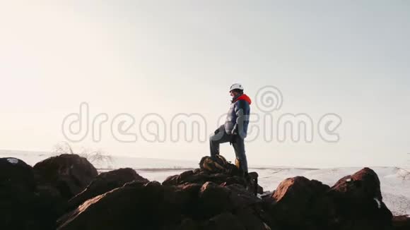 登山者在山顶向远处看操作者移除较低的角度视频的预览图