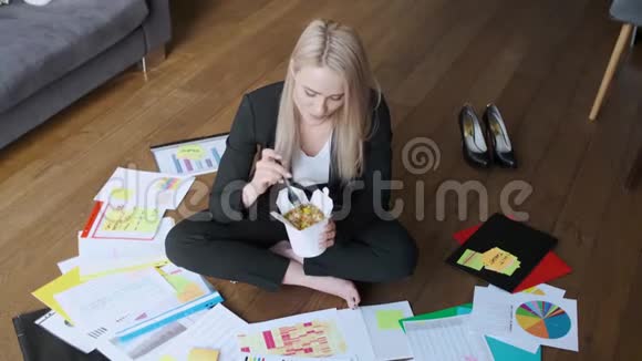 年轻的白种人商业女性工作和吃亚洲食物视频的预览图