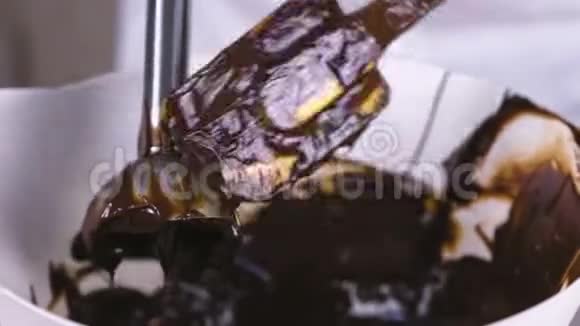 用抹刀从搅拌机里清理液体巧克力特写镜头视频的预览图