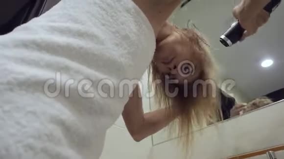 漂亮的女人在浴室洗澡后用吹风机吹干头发视频的预览图