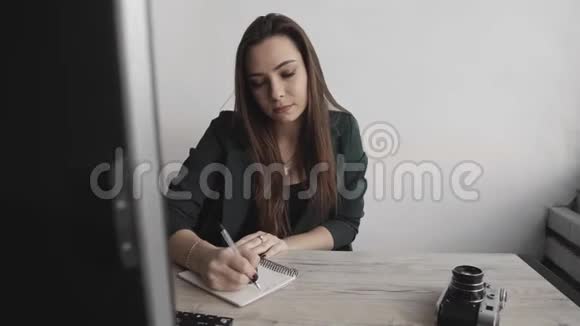 女商人在笔记本上写东西创业女企业家学生在工作场所学习书写笔记视频的预览图