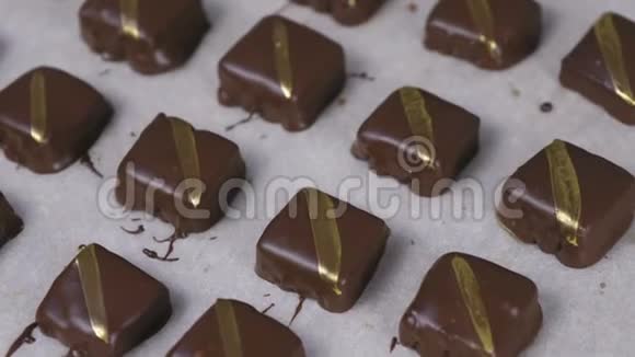美丽美味的巧克力手工糖果与金色条纹面包纸特写镜头视频的预览图