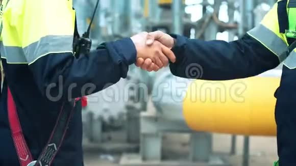 两名穿制服的男工在重工业工厂握手视频的预览图