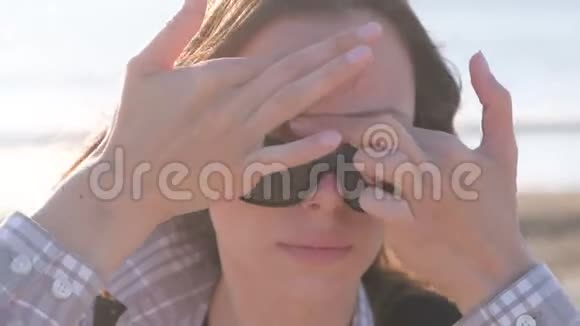 在海滩上做面部按摩的女人前景视频的预览图