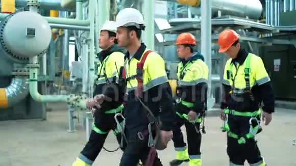 生产现场穿着防护服和戴着安全帽的专业工人队伍视频的预览图
