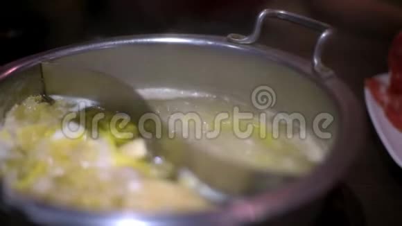 4K亚洲女人用筷子在中国火锅汤里煮肉视频的预览图