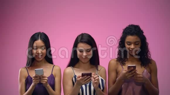 三个可爱的多种族妇女使用移动应用程序和查找模板视频的预览图