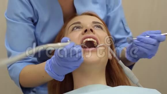 女医生在牙科诊所检查一个年轻女孩牙齿视频的预览图