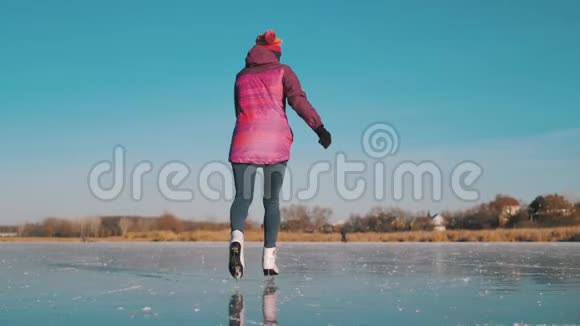 在一个寒冷的冬天年轻女子在冰冻的湖面上滑冰人冬季运动休闲理念视频的预览图