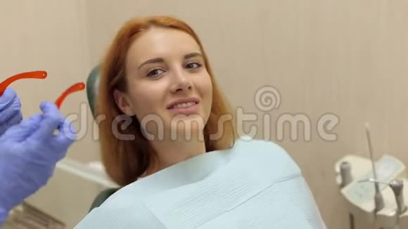 一位女牙医在病人身上戴上防护橙色眼镜视频的预览图