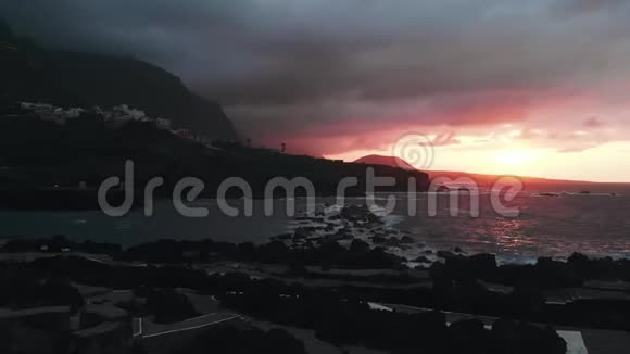 鸟瞰日落附近的Garachico镇一个小海湾和风景如画的西班牙城市的海岸视频的预览图