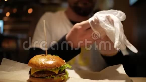 有胡子的人戴手套吃汉堡奶酪汉堡视频的预览图