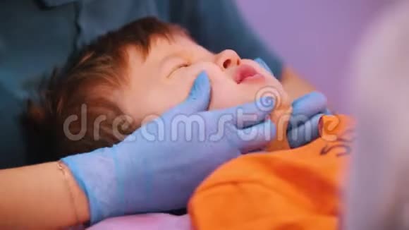 医疗中心一位女医生给婴儿按摩脸患有脑瘫疾病的婴儿关门视频的预览图