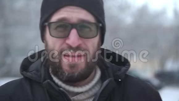 一个留着胡子和眼镜的人走到摄像机前视频的预览图