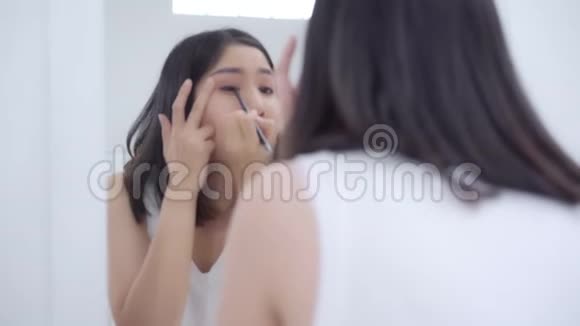 美丽的亚洲女人用眼影在镜子前化妆视频的预览图