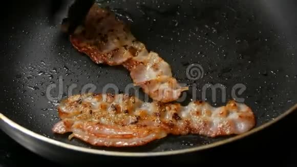 薄的培根片用葵花籽油在热锅里炒不粘涂层男士厨师早餐烹饪视频的预览图