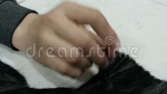 少年的手用毛毡工作用羊毛做画的针白色的黑色毛毡图案视频的预览图