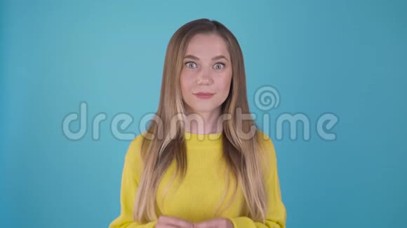 太不可思议了穿着蓝色背景的黄色毛衣的快乐惊讶女孩女孩的情绪和奇迹视频的预览图