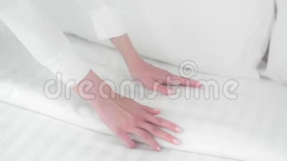 女人整理床铺女佣整理毯子整理床铺新床单床单干净的房间4kUHD道具视频的预览图