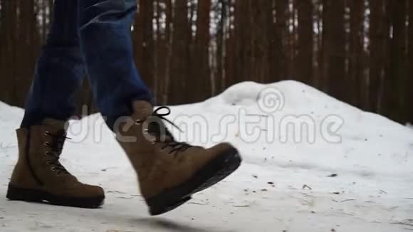 双脚穿着毛毡靴在冬季的风景中缓慢地行走在森林中漫步视频的预览图
