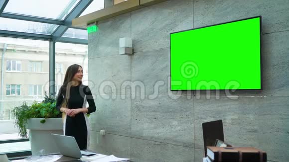 商务女性在会议厅的绿色大屏幕上做演讲视频的预览图