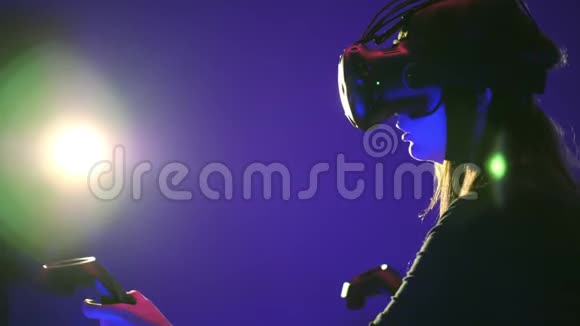 女人玩3D虚拟现实游戏在射击VR游戏中使用控制器射击穿着VR耳机的女孩视频的预览图