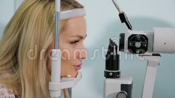 在眼镜店用测试装置测量眼睛的女人视频的预览图