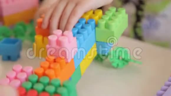 这个男孩扮演游戏设计师孩子折叠一个五彩塑料构造器视频的预览图