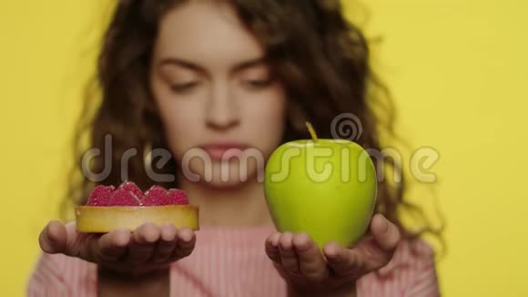年轻女子拿着黄色背景的苹果水果和浆果蛋糕视频的预览图