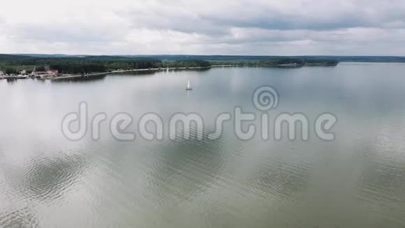 无人机慢慢地飞过湖中的一艘帆船视频的预览图