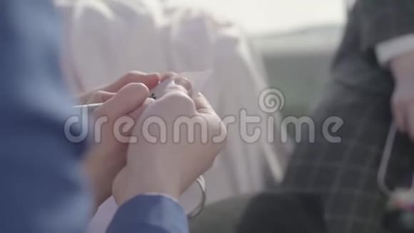 男人和女人的手把小纸藏在手上在上面写上字母M女人的手也拿着金属心视频的预览图