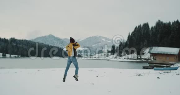 白雪皑皑的湖光山色带着一个大森林的年轻游客高兴地来到了他的目的地视频的预览图
