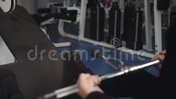 健身器材上英俊的健美运动员训练的后视图视频的预览图