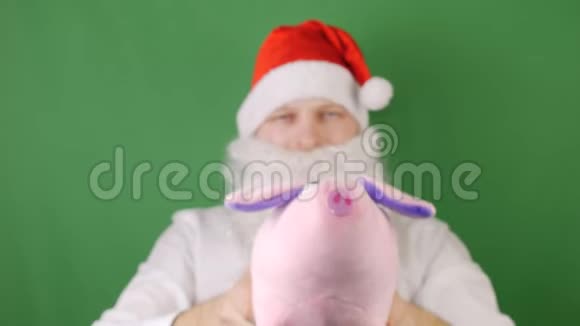 戴着圣诞老人帽子的人戴着绿色Chroma钥匙象征着2019年猪或腮腺炎新年和圣诞节视频的预览图