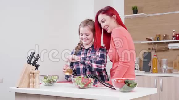 当她母亲靠近她的时候女儿在沙拉上倒油视频的预览图