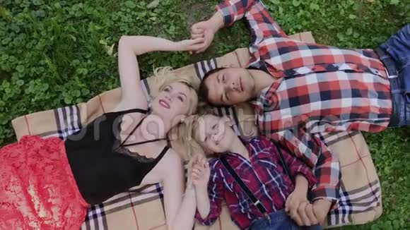 幸福的家庭躺在草地上头对着对方视频的预览图