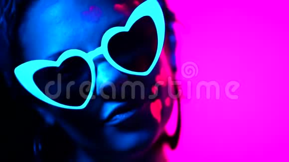 霓虹灯中心形眼镜的时尚模特女性肖像在紫外线下发光的特殊化妆品视频的预览图
