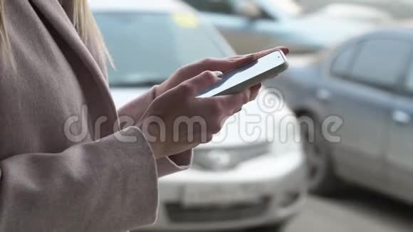 在拥挤的街道背景下一个女人手里拿着一部手机的特写镜头视频的预览图