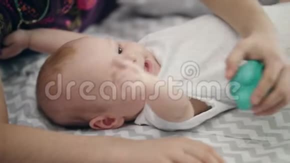 活跃的婴儿躺在床上可爱的小男孩试图推翻视频的预览图