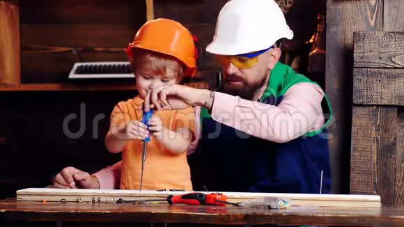 修和车间理念父亲带胡须的家长教小儿子使用工具螺丝刀孩子孩子忙着视频的预览图