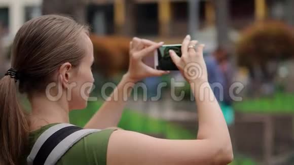 一个女孩带着一个孩子在旅行中用手机拍照把手指按在智能手机屏幕上视频的预览图