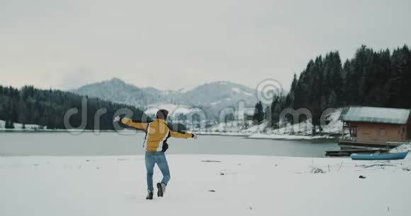 白雪皑皑的湖光山色带着一个大森林的年轻游客高兴地来到了他的目的地视频的预览图