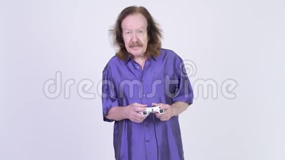 快乐的老人穿着紫色丝质衬衫玩游戏赢了视频的预览图