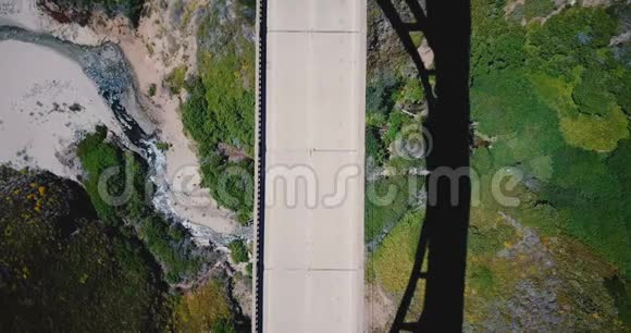 大气俯视锁定空中拍摄汽车驾驶在比克斯比溪桥在1号高速公路与美丽的自然周围视频的预览图