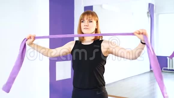 年轻妇女做锻炼以发展手部背部和腹部肌肉视频的预览图