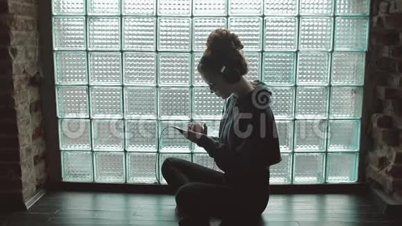 女孩坐在地板上听音乐视频的预览图