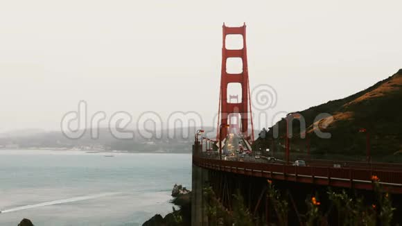 在美国旧金山经过标志性的金门大桥傍晚的汽车交通和鲜花壮观的日落时光流逝视频的预览图