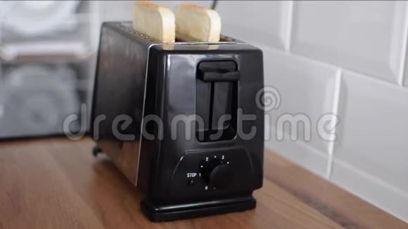 面包从烤面包机上弹出女人从烤面包机里拿出烤面包视频的预览图
